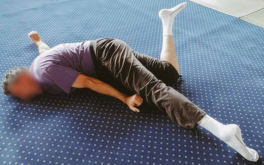 Personne allongée au sol corps en torsion pendant une séance de psychanalyse corporelle